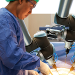 Smart precision healthcare technology , artificial intelligence concept. Automation robot hand machine in operating room and surgery doctors in futuristic hospital