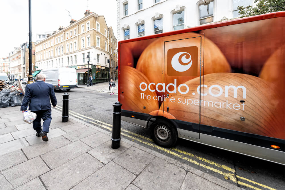 Ocado online store grocery shopping delivery supermarket sign on truck with red orange color in Covent Garden near SoHo