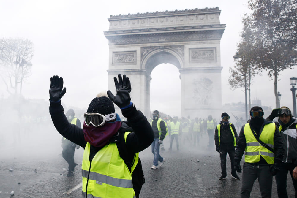 Riot Police uses a water canon and tear gas against demonstrators during a protest against the rising of the fuel and oil prices by people wearing yellow vests