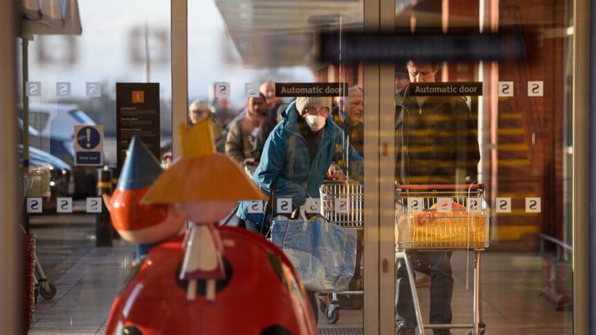 Shoppers queue before the 7am opening time to enter a Sainsbury's supermarket in Oldham, northern England, on March 20, 2020.
