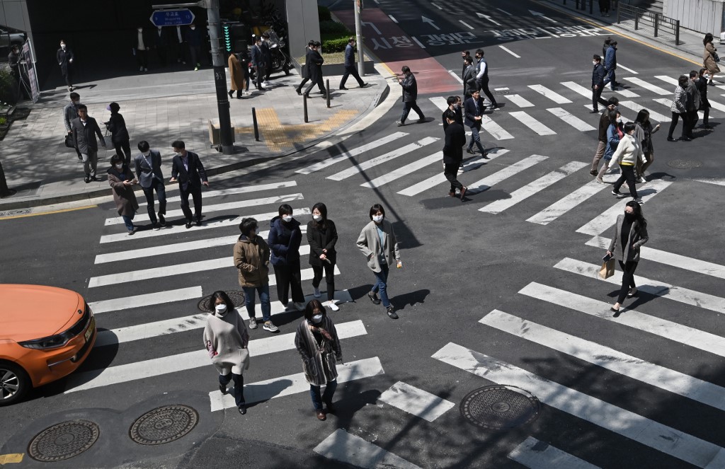 Pedestrians wearing face masks cross the road in Seoul, South Korea