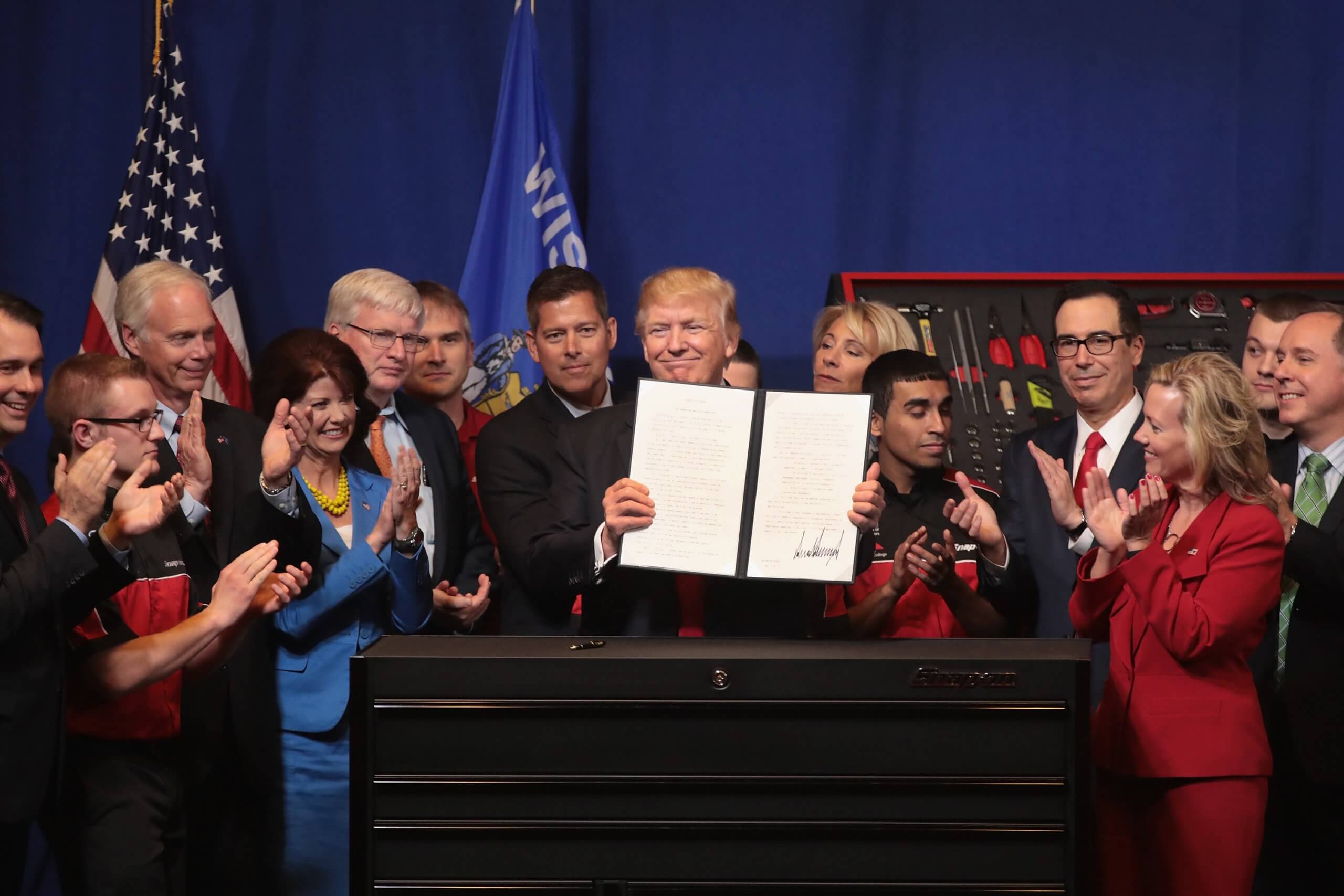 President Donald Trump signs an executive order to try to bring jobs back to American workers and revamp the H-1B visa guest worker program during a visit to the headquarters of tool manufacturer Snap-On in Wisconsin.