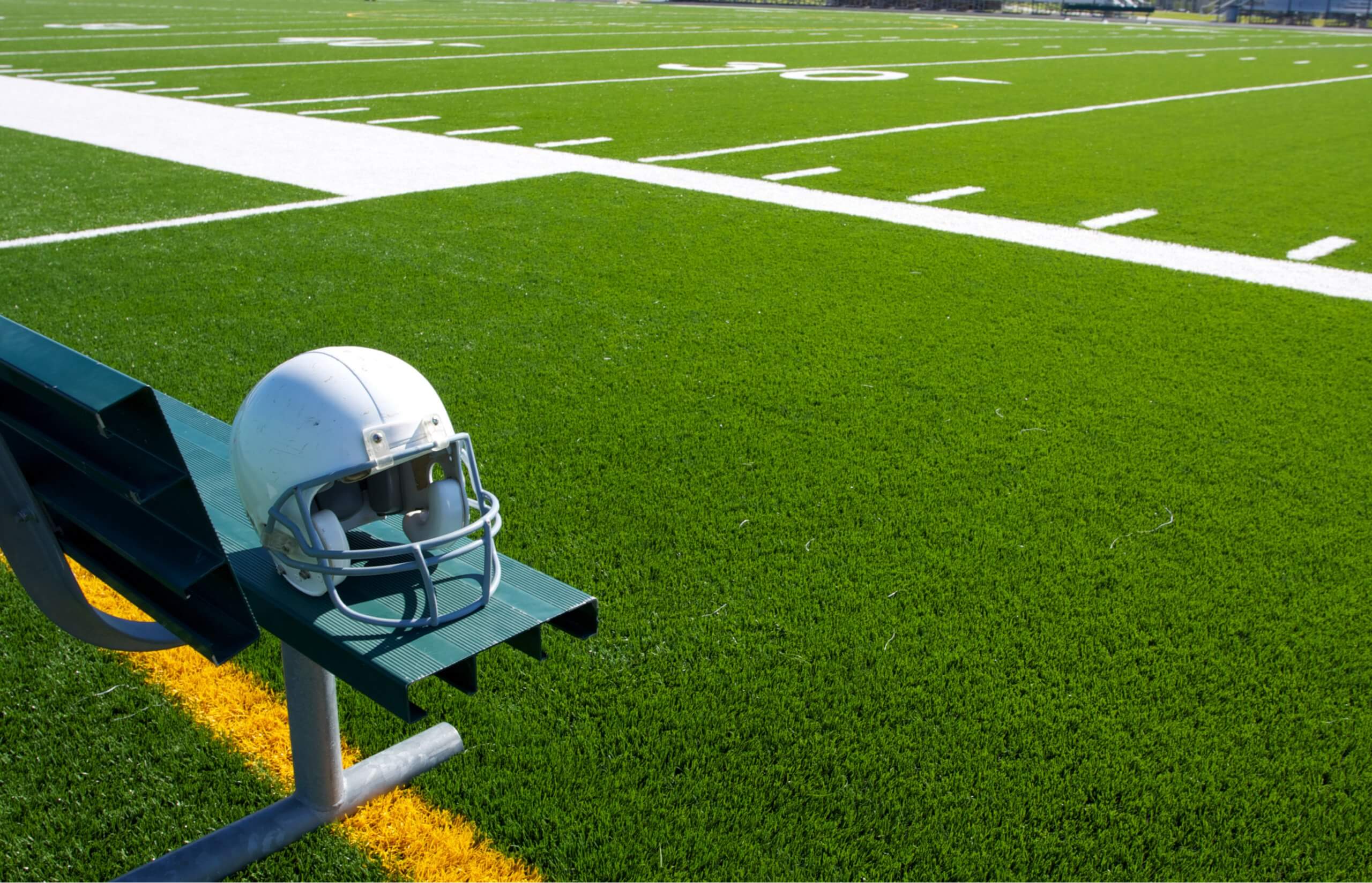 American Football Helmet on the Bench with the field beyond