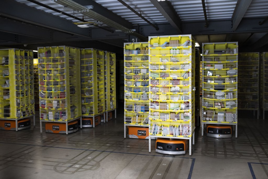 Hundreds of lawnmower-sized robots that move around shelving units in a closed field are seen during a tour of Amazon's Fulfillment Center.