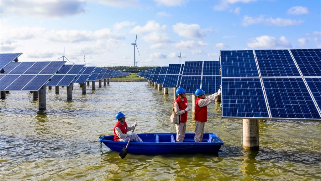 China renewable energy - inspecting PV solar panels on fishing lake