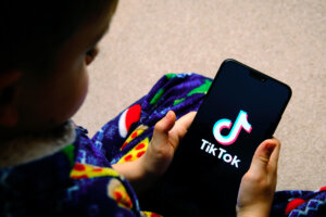 Child using TikTok, which will have to adhere to the Digital Services Act as a VLOP. Source: Shutterstock