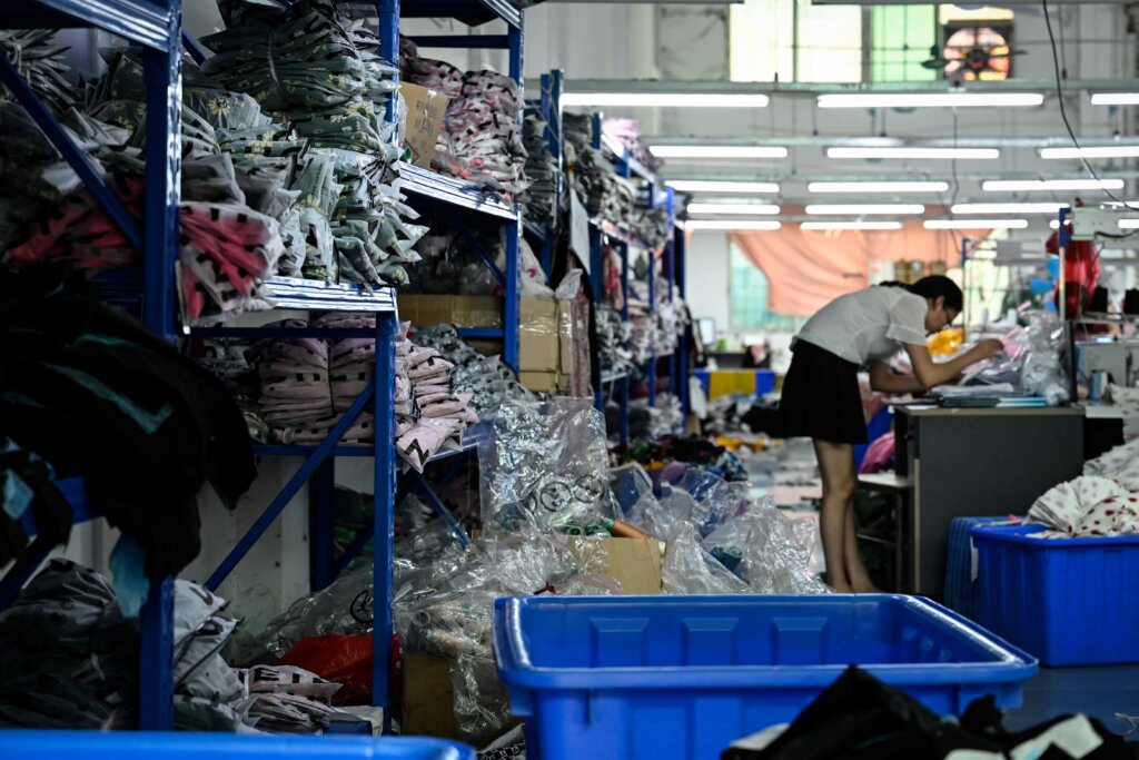 A worker makes clothes at a garment factory that supplies Shein. (Photo by Jade Gao / AFP)