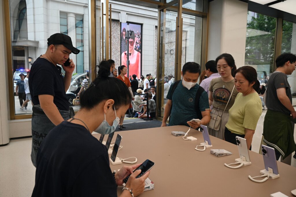 People look at mobile phones in Huawei's flagship store in Shanghai on September 25, 2023, after queuing up for hours hoping to be able to buy the tech giant's latest Mate 60 Pro mobile phone. (Photo by REBECCA BAILEY / AFP)